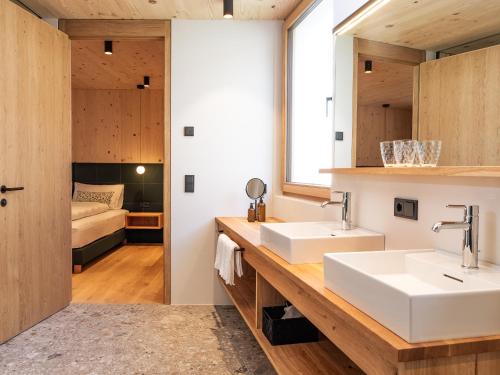 un bagno con due lavandini e una camera da letto di Kreithner luxury apartments a Vandoies