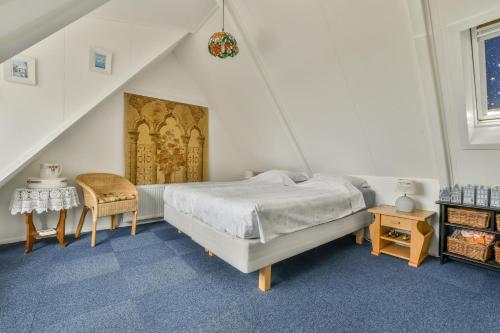 Un dormitorio con una cama, una mesa y una silla. en B&B De Duinhoek, en Beverwijk