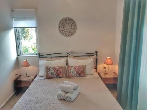 una camera da letto con un letto con due asciugamani sopra di Dimitra's Pretty Apartment 4 klm away from Chora ad Andro