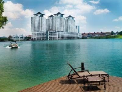 a bench sitting on a dock with a boat in the water at Heritage cando in Seri Kembangan