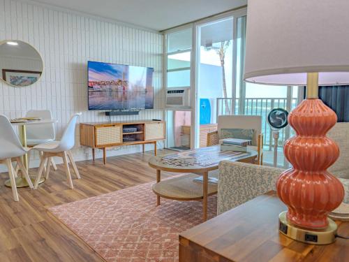 a living room with a couch and a table with a lamp at Beachfront Studio w Amazing Views in Hauula
