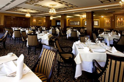 a dining room with white tables and chairs at Primoretz Grand Hotel & Spa in Burgas City