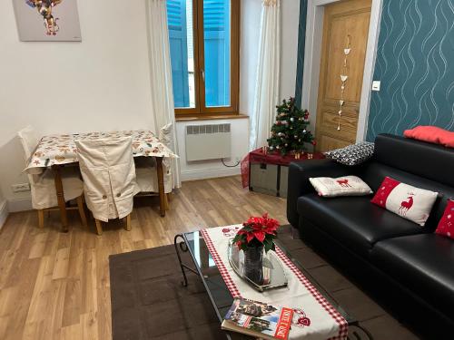 un soggiorno con divano e tavolo con albero di Natale di Les volets bleus a Sainte-Marie-aux-Mines