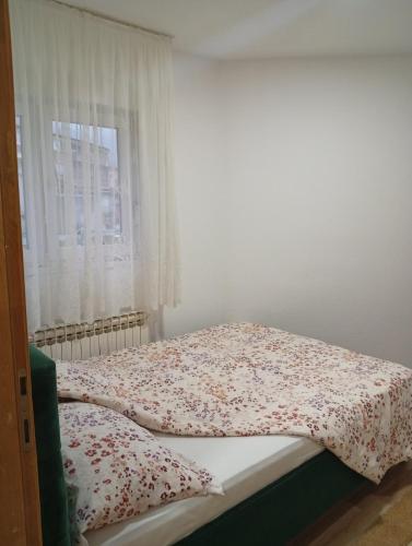 a bed in a room with a window at Daily rental apartment Travnik in Travnik