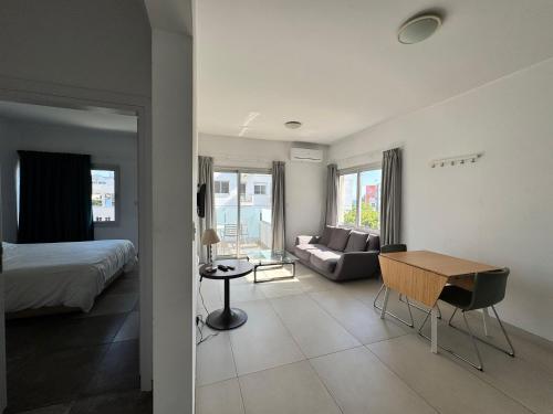 a room with a bed and a desk and a couch at Vega Apartments in Limassol
