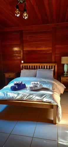 a bed in a wooden room with two towels on it at Wooden House in Maria da Fé