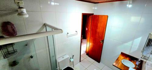 a bathroom with a shower and a red door at Wooden House in Maria da Fé