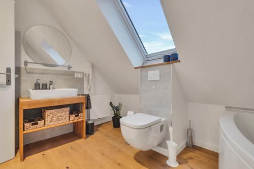 a bathroom with a toilet and a sink and a skylight at Novita apartment 2 - central - balcony - mountain views in Bad Harzburg