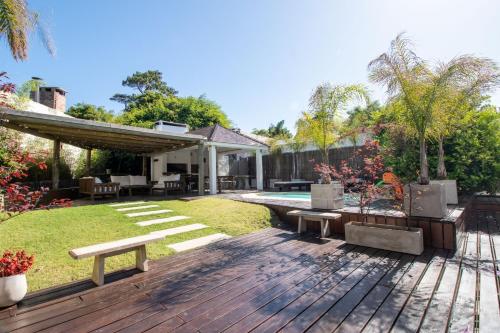 un cortile con una terrazza in legno con panchine di Villa Kunterbunt Punta del Este a Punta del Este