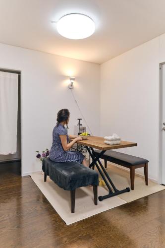 a woman sitting at a table in a room at HigashiNakano 3 rooms 1 bath with 2 different view in Tokyo