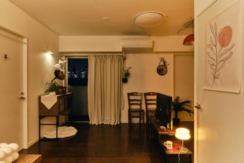 a living room with a couch and a table and chairs at HigashiNakano 3 rooms 1 bath with 2 different view in Tokyo