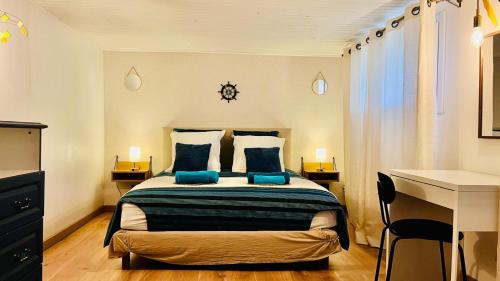 a bedroom with a large bed with blue pillows at L'Escale de Pontcarré - Disneyland Paris in Pontcarré