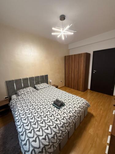 a bedroom with a bed with a black and white comforter at Comfort Stay Apartment - Free Parking & Wi-Fi in Chiajna