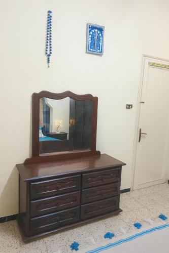 a mirror on top of a dresser in a room at Chez Naceur Suite in Tozeur