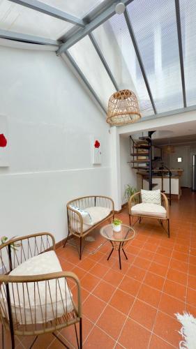 Zimmer mit Stühlen, Tischen und einer Glasdecke in der Unterkunft Casa Moras in Necochea