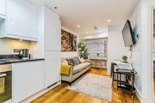 a kitchen and a living room with a couch at New 1 Bed Apartment 12 mins to Central London and Gatwick Airport in Croydon