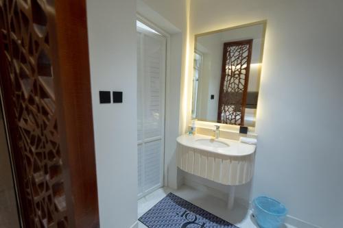 un baño con lavabo y espejo en عبر الاصالة, en Rafha