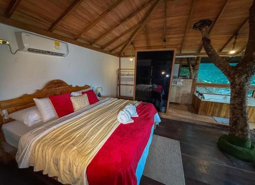 a bedroom with a large bed and a tree at Ecohotel Alflo Inn in Villeta