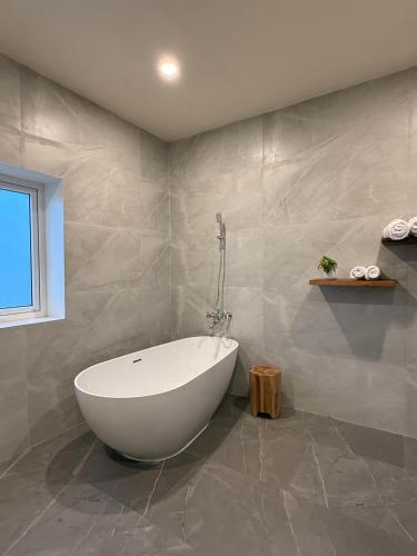 a bathroom with a white tub in a room at Sacred Grove Resort Sohra in Cherrapunji