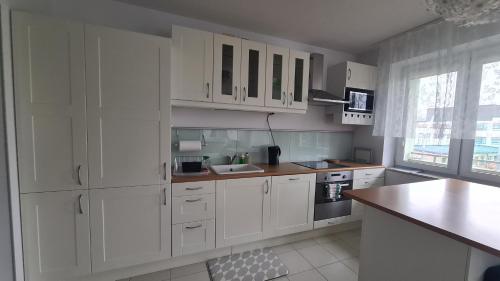 a white kitchen with white cabinets and a counter at Apartament Leśny Ząbki in Ząbki