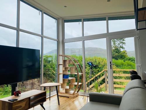 a living room with a large window and a tv at Luxury Portree Cottage Hillside in Portree