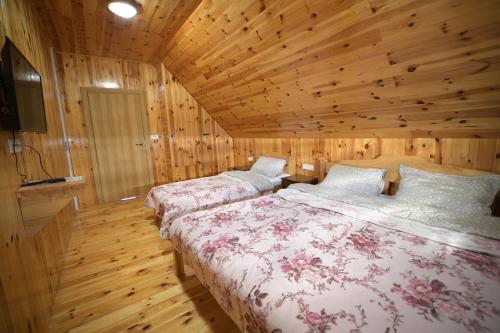 にあるApartmani pod Durmitoromの木製の壁の部屋にベッドが2つある