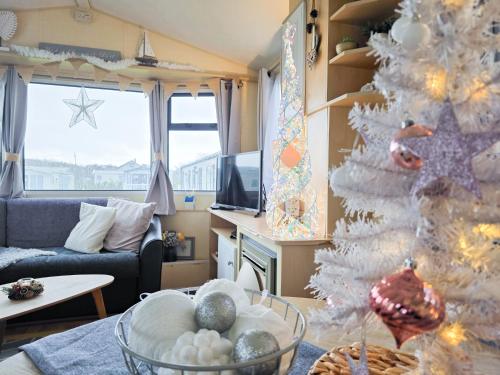ein Wohnzimmer mit einem Weihnachtsbaum und einer Couch in der Unterkunft Ocean Breeze in Truro