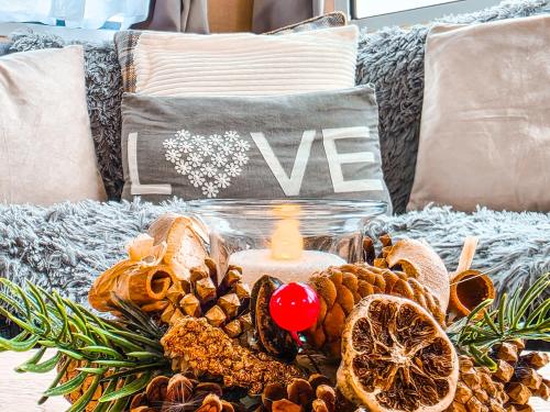 Eine Kerze steht auf einem Sofa neben einem Haufen Nüsse. in der Unterkunft Ocean Breeze in Truro