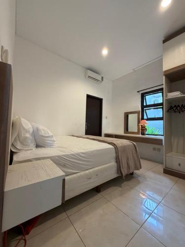 a bedroom with a large bed and a window at Pandan de Bali in Ungasan