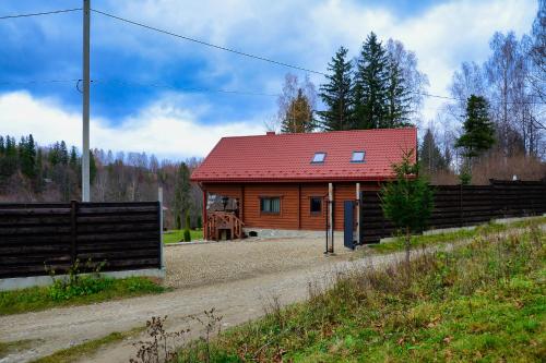 eine kleine Holzhütte mit rotem Dach in der Unterkunft Флояра in Kozmacz