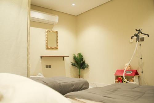 a bedroom with two beds and a mirror at Chicago Apartment in Al Khobar