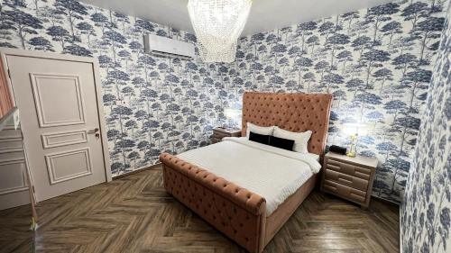 a bedroom with a bed with blue and white wallpaper at The Pink Pool - Swimming pool in Ras al Khaimah