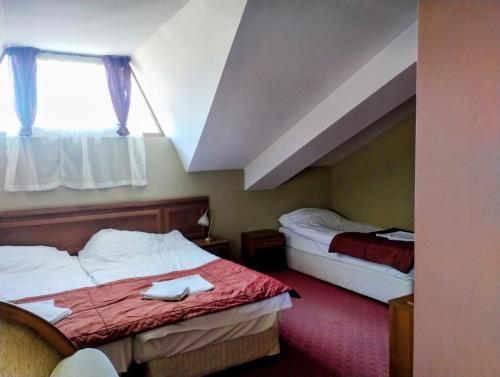 a hotel room with two beds and a window at hotel Sofia in Bansko