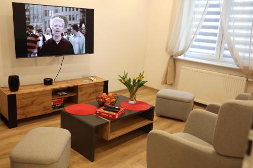 a living room with a tv and a table and chairs at Apartament Nowa in Jarocin