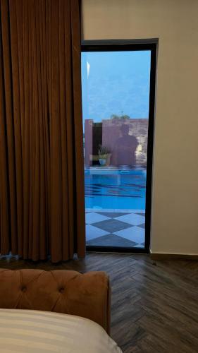 a bedroom with a view of a pool through a glass door at The Pink Pool - Swimming pool in Ras al Khaimah
