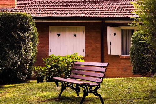 ławka przed domem z dwoma białymi drzwiami w obiekcie Pousada O Cantinho da Raposa w mieście Monte Verde