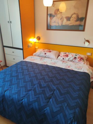 a bedroom with a bed with a blue blanket at Panoramic Suite in Passo del Tonale