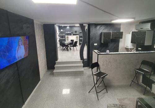 Una sala con un bar con sillas y un televisor. en Glow Sahara, en Focşani