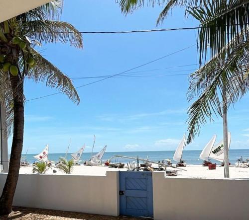 a beach with a blue dresser and palm trees and the ocean at Pousada Caponga Praia Mar in Cascavel