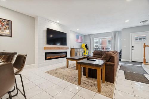 a living room with a couch and a table at Heart of Southie - Hot Tub + Walk to Top Bars in Boston