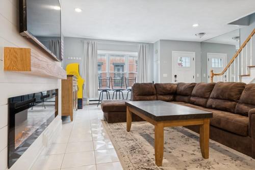 a living room with a couch and a coffee table at Heart of Southie - Hot Tub + Walk to Top Bars in Boston