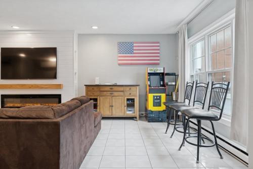 a living room with a couch and chairs and an american flag at Heart of Southie - Hot Tub + Walk to Top Bars in Boston