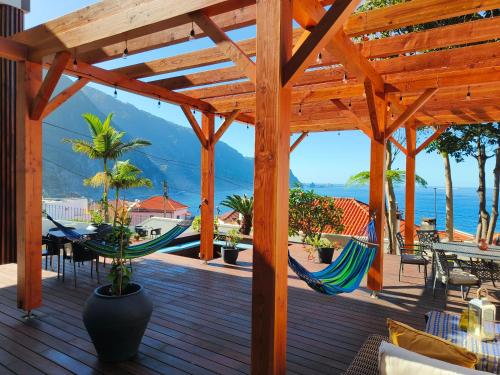 a deck with hammocks and a view of the ocean at North Madeira Guesthouse in Seixal
