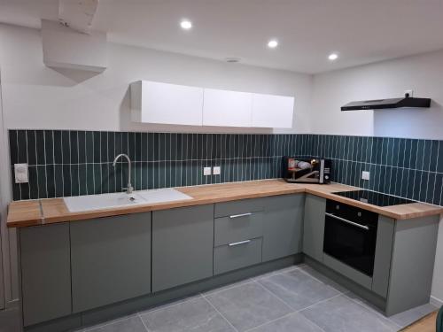 een keuken met een spoelbak en een aanrechtblad bij Maison Fantastique in Jargeau