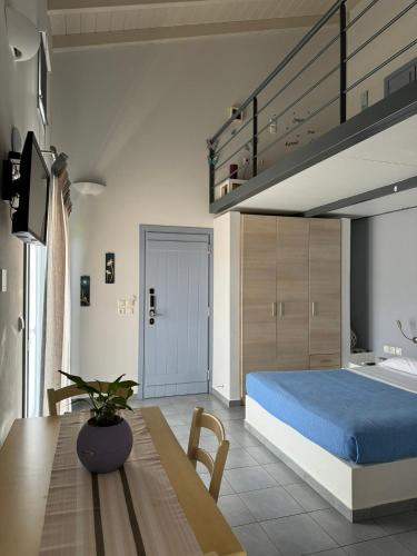 a bedroom with a bed and a table with a blue bed at Zathea Apartments in Agia Pelagia
