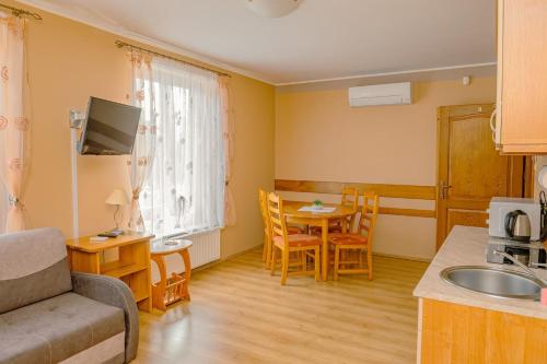 a kitchen and living room with a table and a couch at Apartamenty Klemens in Puck
