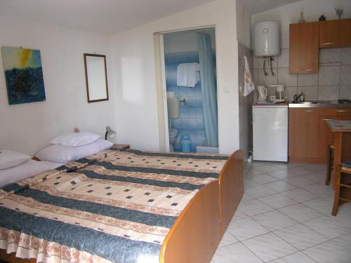 1 Schlafzimmer mit einem großen Bett und einer Küche in der Unterkunft Apartmani Plach in Krk
