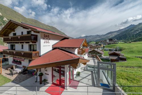 a building with a view of a town with mountains at Das Hochegg - Apartments in Obergurgl