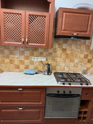 a kitchen with wooden cabinets and a stove top oven at Будинок на Духновича in Mukacheve
