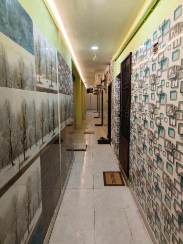 einen Flur mit Bildern an den Wänden eines Gebäudes in der Unterkunft BMR home stay inn in Srikalahasti